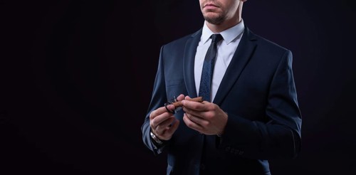 Image of an adult stylish man in a suit with a cigar. Cigar clubs concept.