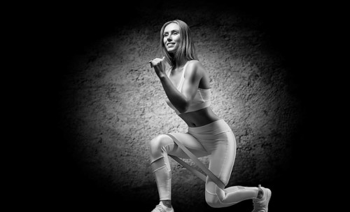 Charming girl does an exercise called lunges. Elastic band for training. The concept of fitness
