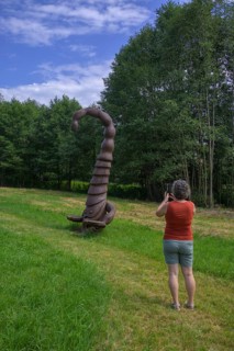 Woman photographing a wooden scorpion figure