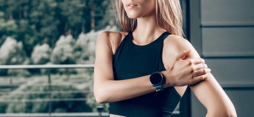 Charming girl posing with a smart watch. No name portrait. The concept of bodybuilding