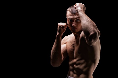 Professional boxer posing in the studio. He stands in front of the camera and elbows. The concept of sport