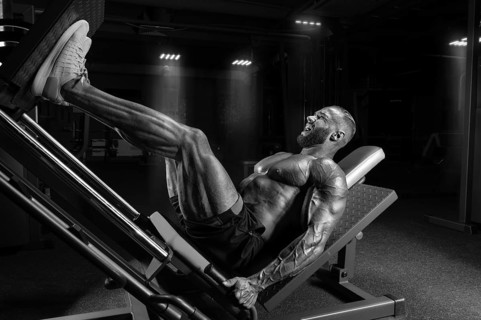 Professional athlete performs a leg exercise. Bodybuilding