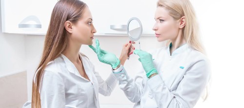 Portrait of two girls in white coats. The concept of cosmetology