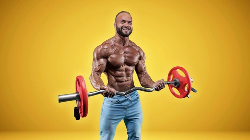 Isolated professional sportsman on a yellow background. Bodybuilding concept. Panorama. Advertising of a gym and sports nutrition.