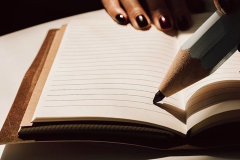 Large pencil is standing on a sheet of a notebook. Concept of business interviewing.