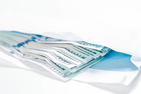 Pack of hundred-dollar bills lies in an envelope. The concept of bribery and corruption.