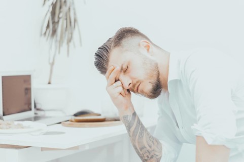 The man in the shirt is very upset by the unpleasant news. He tiredly supported his head and closed his eyes. The concept of disappointment