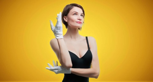 Portrait of a beautiful woman in a black dress and white gloves. Jewelry store concept. Sales consultant.