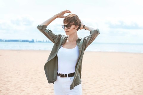 Image of a beautiful woman on the beach of the Gulf of Finland in St. Petersburg. Windy weather. Happiness