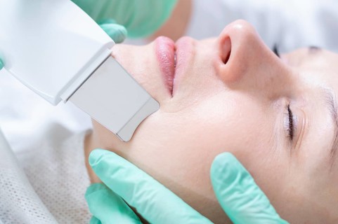Young pretty woman receiving treatments in beauty salons. Ultrasonic cleaning procedure. Hardware cosmetology.