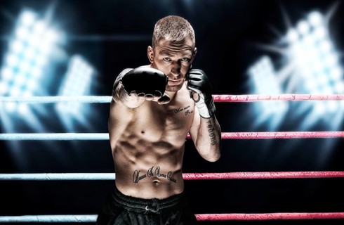 Mixed martial artist posing in the ring against spotlights. Concept of mma