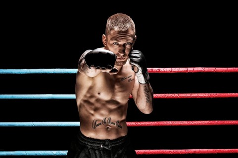 Mixed martial artist posing in boxing ring. Concept of mma