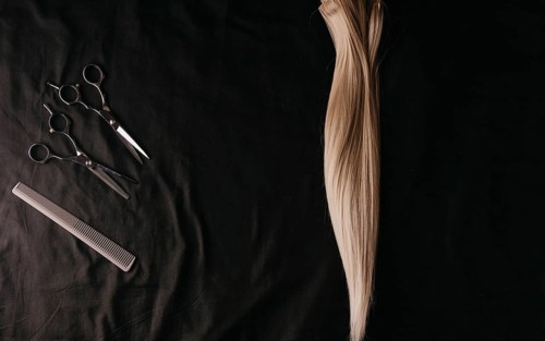 Natural hair of different colors with scissors and comb. concept of hair care and hairdressing services