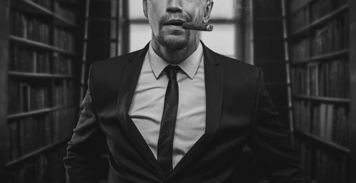 Portrait of a stylish man in a suit with a cigar. Business concept.