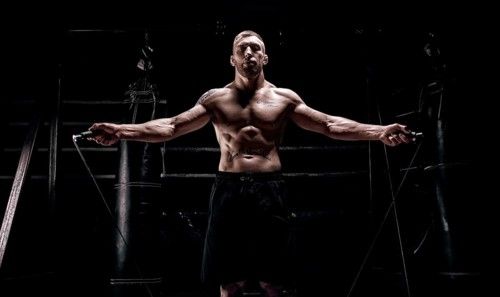 The athlete jumps on a skipping rope in the gym opposite the boxing ring. The concept of sport