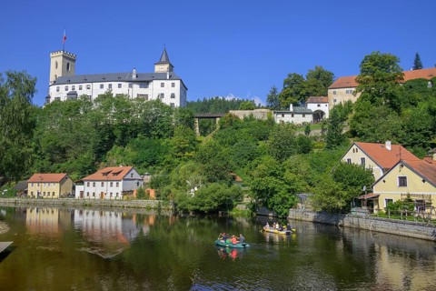 Rubber dinghies navigate the Vltava river behind the castle of