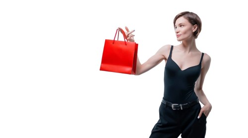 Portrait of stylish adult woman posing in studio on white background with red gift bag. Valentine's Day concept. Holidays and gifts