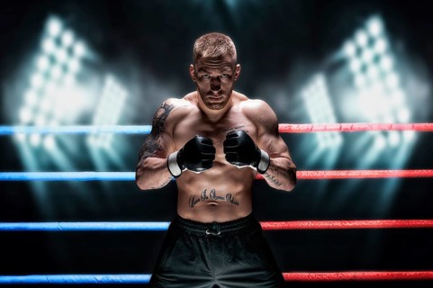 Mixed martial artist posing in the ring against spotlights. Concept of mma