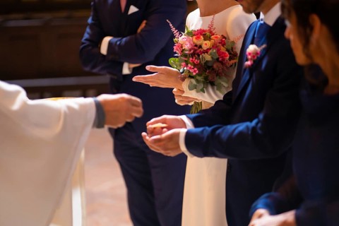 Priest at a wedding at the ceremony gives bread to the bride and groom at the wedding