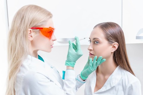 Portrait of the beautician and patient. The doctor injects botox. Skin rejuvenation and lifting concept.