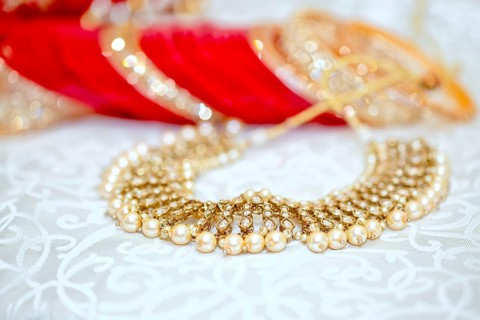 Close-up of an elegant golden pearl necklace with a bokeh background