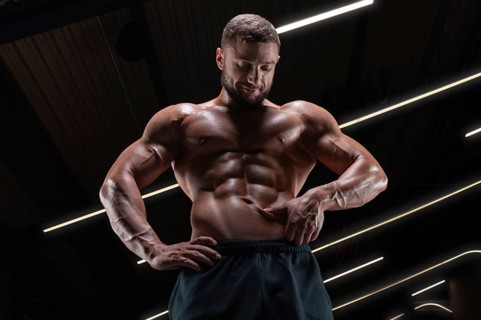 Image of a muscular guy with a naked torso and abs. Gym. Fitness concept