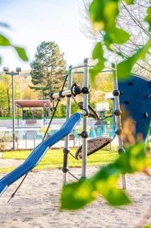Colourful climbing frame with slide on a playground surrounded by nature