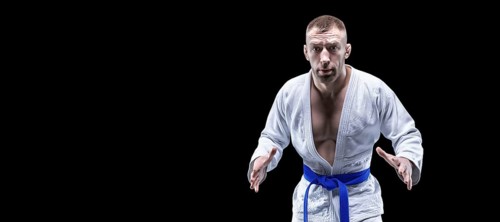 Professional athlete in a kimono with a blue belt prepares for a fight. Concept of karate