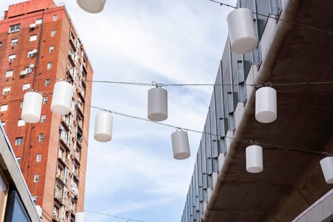 A view looking up at a pattern of hanging white chinese lanterns