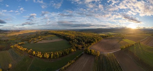 Aerial view of fields vineyards and autumnal forest on the Grossauerhoehe at sunset