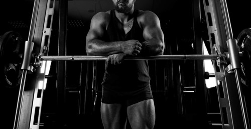 The weightlifter is near the bar