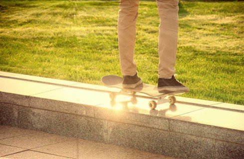 Desperate skateboarder performs dangerous movement on the skateboard at sunset