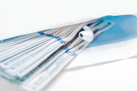 Pack of hundred-dollar bills along with a bug lie in an envelope. The concept of bribery and corruption.
