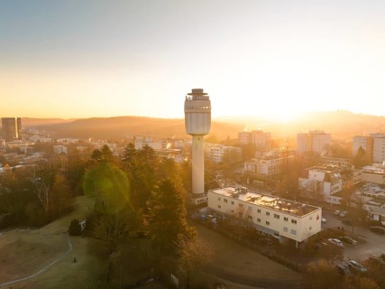 Aerial view of a water tower in the city during a calm sunrise