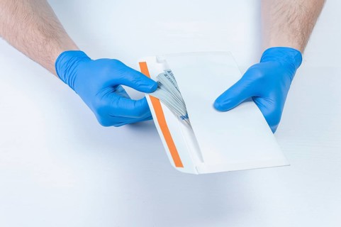 Image of hands in medical gloves holding an envelope with dollars. The concept of corruption in medicine.