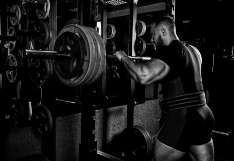Professional athlete prepares to squat with a barbell.