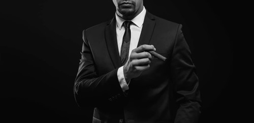 Image of an adult stylish man in a suit with a cigar. Cigar clubs concept.