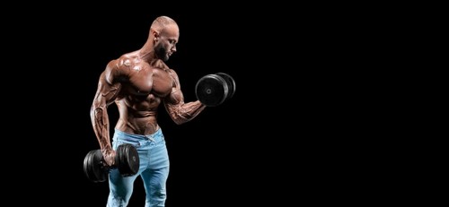 Isolated muscular man on a black background. Bodybuilding and fitness concept. Panorama.