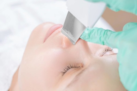 Young pretty woman receiving treatments in beauty salons. Ultrasonic cleaning procedure. Hardware cosmetology.