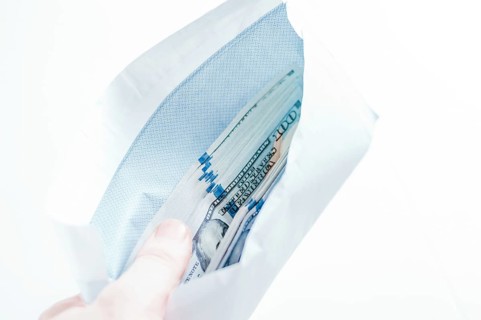 Pack of hundred-dollar bills lies in an envelope. The concept of bribery and corruption.
