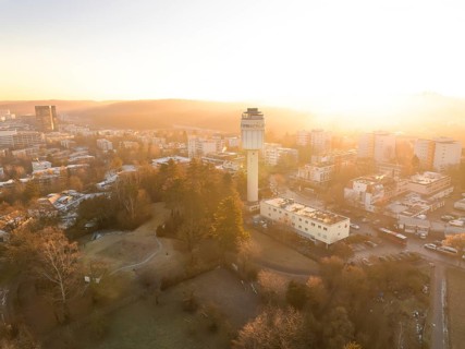 Elevated view of a water tower and the cityscape at sunrise