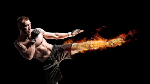 Kickboxer posing in the ring. Middle Kick with a burning foot. The concept of mma