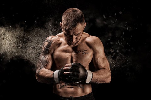 Mixed martial artist posing on a black background. Concept of mma