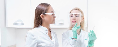 Portrait of two girls in white coats. The concept of cosmetology