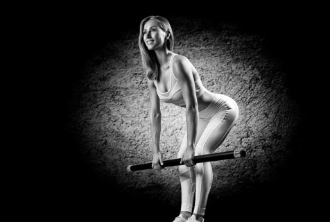 Charming girl does an exercise called deadlift. Bodybar. The concept of fitness