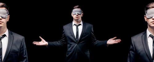 Combined portrait of a man in a mask for sleeping. He is standing on a black background. Concept of blind business