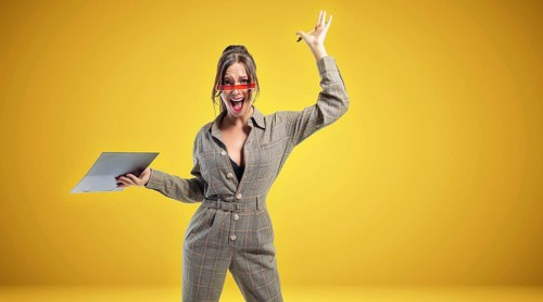 Portrait of a woman in a suit with a tablet. She waves her hand emotionally. Sports betting concept.