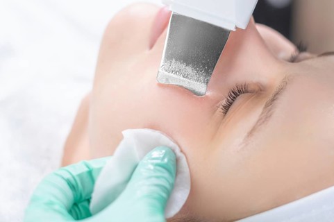 Young pretty woman receiving treatments in beauty salons. Ultrasonic cleaning procedure. Hardware cosmetology.