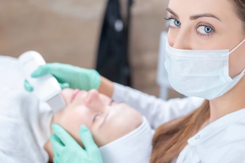Portrait of a beautician who cleans the patient's face with an ultrasound device. Beauty salons concept.
