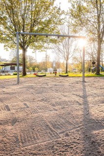Sunny playground with swings and sandy area